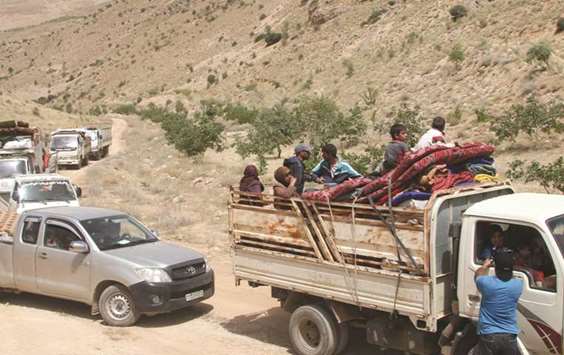 Syrian refugees ride vehicles in the Lebanese eastern border town of Arsal as they head towards the Syrian region of Qalamoun yesterday.