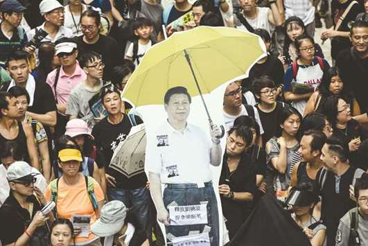 A cardboard cut-out of Chinau2019s President Xi Jinping holding a yellow umbrella, a symbol of the 2014 u2018Umbrella Movementu2019, being carried during a protest march in Hong Kong yesterday, coinciding with the 20th anniversary of the cityu2019s handover from British to Chinese rule.