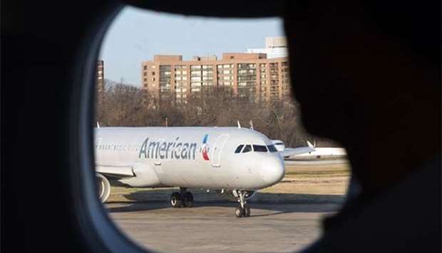A passenger looking out of his window at an American Airlines plane at Reagan National Airport in Arlington, Virginia. American Airlines said on Wednesday it is ending its codeshare relationships with Qatar Airways and Etihad Airways.