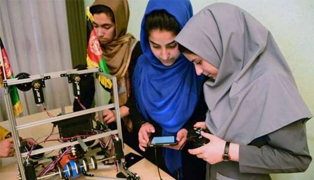 Teenagers from the Afghanistan Robotic House, a private training institute, work on a robot at the Better Idea Organisation centre in Herat.