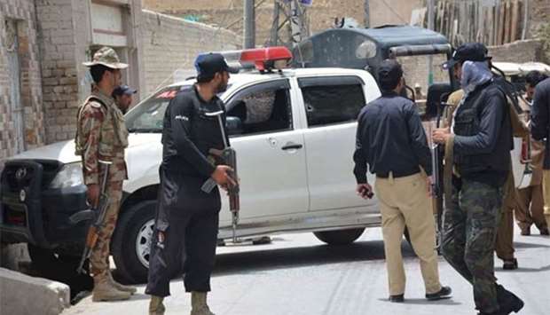 Pakistani security personnel stand next to a police vehicle after an ambush by gunmen in Quetta on Thursday.