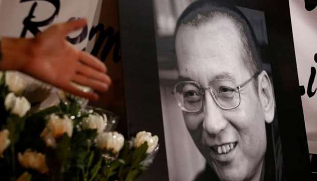 Flowers are laid beside a photo the late Nobel Laureate Liu Xiaobo, outside China's Liaison Office in Hong Kong, China.