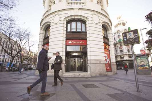 Pedestrians pass a Banco Santander bank branch in Madrid. Santander InnoVentures is investing in Pixoneye and Curve, both based in the UK, and Gridspace, located in the US, according to a statement.
