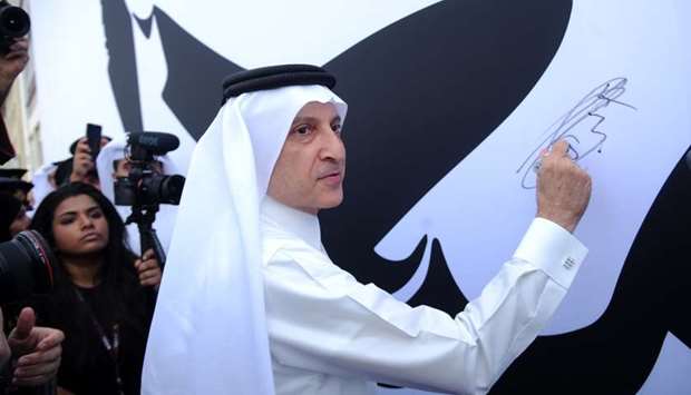 Qatar Airways Group Chief Executive Akbar al-Baker signs on the giant canvas, which displays the iconic image of His Highness the Emir Sheikh Tamim bin Hamad al-Thani at the airlineu2019s corporate headquarters yesterday. PICTURE: Ram Chand