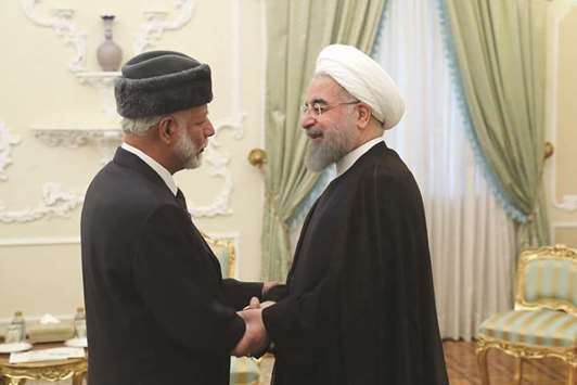 Iranian President Hassan Rouhani greets Omanu2019s Foreign Minister Yusuf bin Alawi in Tehran.