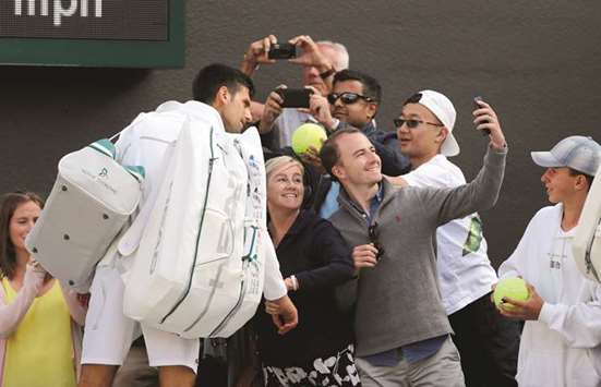 Serbiau2019s Novak Djokovic poses for a picture with spectators after he retired from his quarter-final match against Czech Republicu2019s Tomas Berdych with an injury.