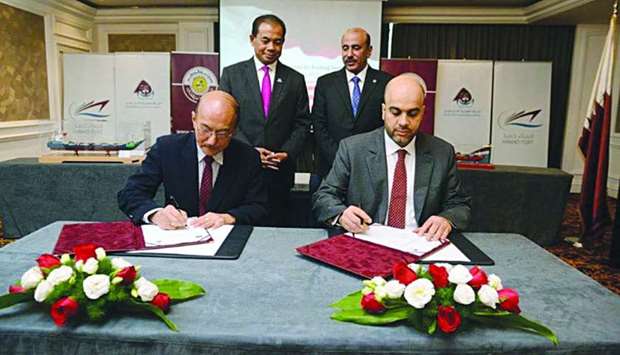 CEO of Mwani Qatar Captain Abdulla al-Khanji and a representative of the Malaysian ship builder signing the agreement as Qatar Transport and Communications Minister HE Jassim Saif al-Sulaiti looks on.