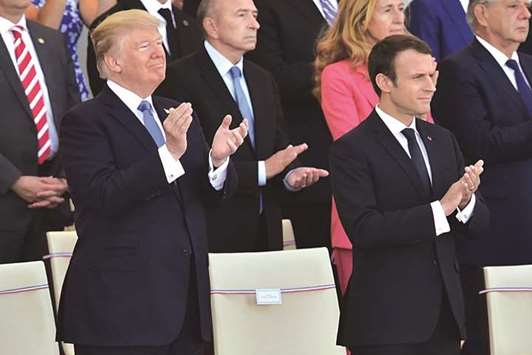US President Donald Trump, left, and his French counterpart Emmanuel Macron applaud as they watch the annual Bastille Day military parade on the Champs-Elysees avenue in Paris yesterday.