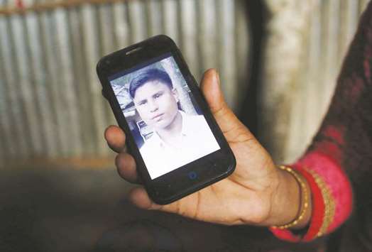 Noor Ankis shows the picture of her husband Ayub, a leader of the unregistered makeshift camp in Kutupalong, who was killed late last month, in Coxu2019s Bazar.