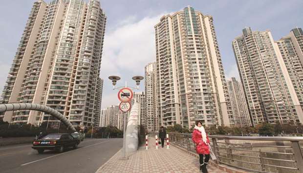 Women walk in front of a housing complex in Shanghai. Chinau2019s policy makers have steadily tightened regulations on the property market over the past year or so to prevent a bubble, though new-home sales still climbed 13% in May from a year before, and prices of new apartments jumped more than 10% in Beijing, Shanghai and Guangzhou.