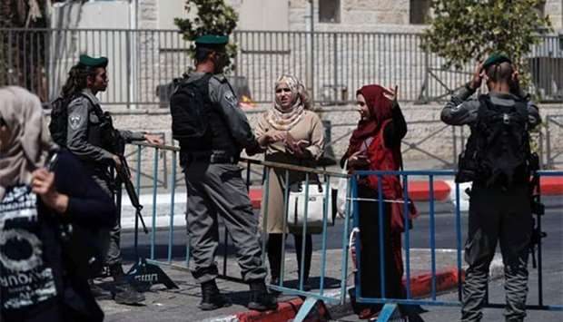 Israeli border policemen stand guard outside Damascus Gate on Saturday, after security forces locked down parts of Jerusalem's Old City and a holy site remained closed.