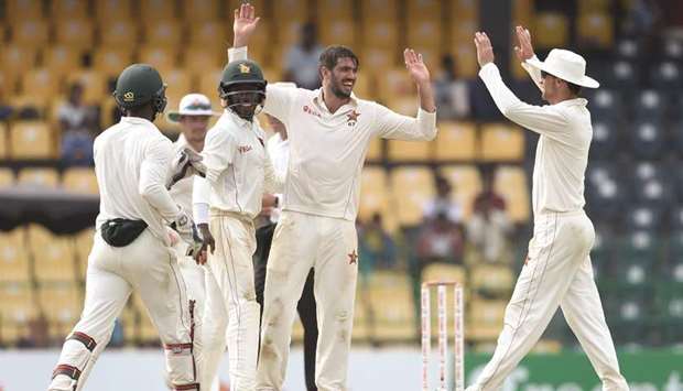 Zimbabweu2019s captain Graeme Cremer (second right) celebrates with his teammates after dismissing Sri Lankan batsman Niroshan Dickwella during the second day of the one-off Test match at the R Premadasa Cricket Stadium in Colombo yesterday. (AFP)