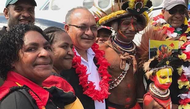 Papua New Guinea Prime Minister Peter O'Neill (C) posing as he is welcomed as he returns to Port Moresby