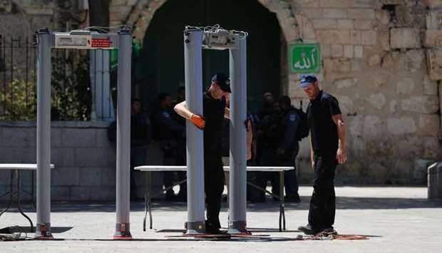 Israeli border policemen install metal detectors outside the Lion's Gate, a main entrance to Al-Aqsa mosque compound, in Jerusalem's Old City