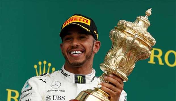 Mercedes\' Lewis Hamilton celebrates his win on the podium.