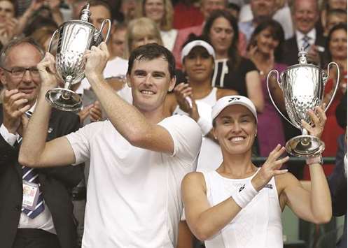 Britainu2019s Jamie Murray (L) and Switzerlandu2019s Martina Hingis hold their Wimbledon mixed doubles winners trophies yesterday.