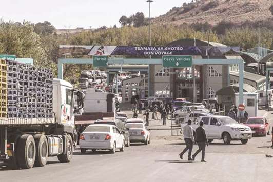 People and vehicles move to cross the Lesotho and South Africa border at the Maseru bridge border post.