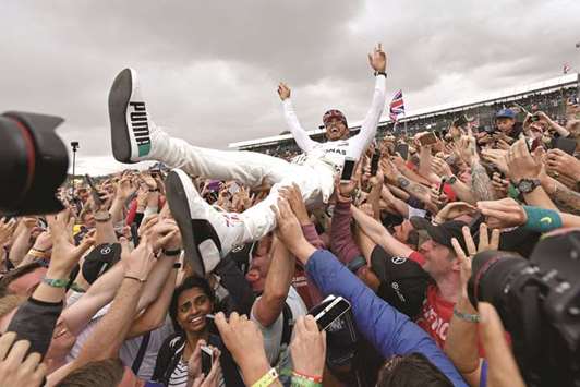 Mercedes driver Lewis Hamilton is celebrated by fans after his British Grand Prix win at Silverstone circuit yesterday. (AFP)