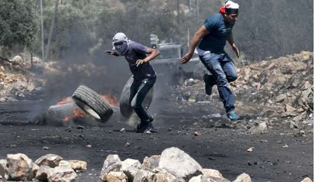Palestinian protesters run for cover during clashes with Israeli security forces following a weekly demonstration against the expropriation of Palestinian land by Israel in the village of Kfar Qaddum, near Nablus in the occupied West Bank. July 14, 2017 file picture.