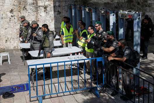 Israeli border police stand guard by newly-installed security metal detectors at the entrance to Al-Aqsa compound yesterday. took control over the Al-Aqsa Mosque after the 1967 war, expanding their ambitious schemes to Judaise Jerusalem, demolish the Al-Aqsa Mosque and establish the alleged temple and by increasing their settlement expansionu2019s activity surrounding the city of Jerusalem from all directions.