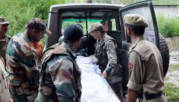 Indian army personnel and policemen move the body of a soldier reportedly killed along the Line of Control to a morgue in the district of Rajouri, some 159kms from Jammu, on Monday.