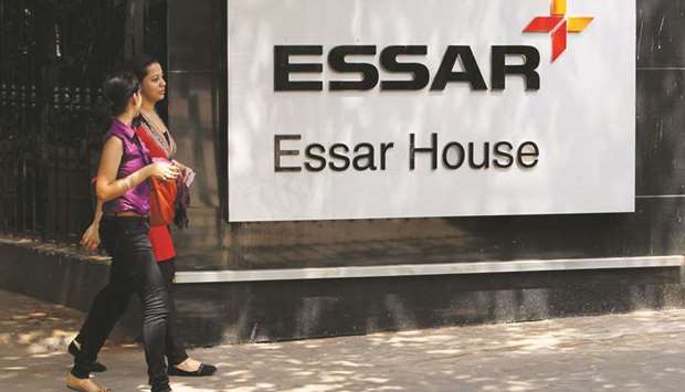 Employees walk past an Essar Group logo outside its headquarters in Mumbai. The company filed a case against the Reserve Bank of India to halt the insolvency proceedings, calling the move arbitrary.