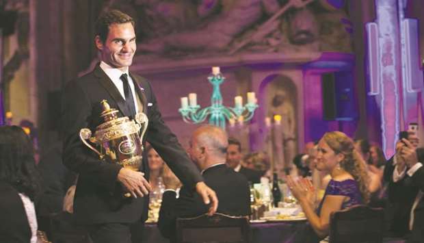 Switzerlandu2019s Roger Federer arrives with his trophy at the Champions Dinner in central London on Sunday. (AFP)