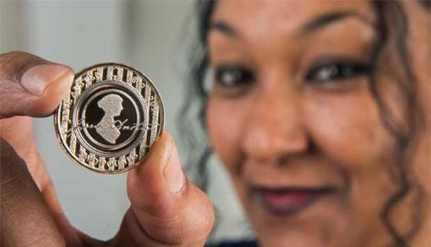 Royal Mint designer Dominique Evans shows the reverse of the special edition u00a32 coin featuring author Jane Austen, released to coincide with her death 200 years ago.