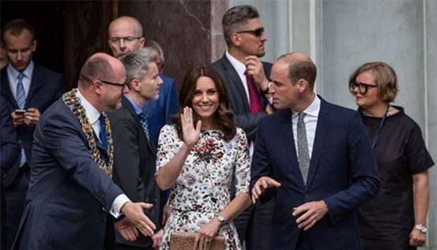 Britain's Prince William, Duke of Cambridge, and his wife Kate, the Duchess of Cambridge are seen as the mayor of Gdansk, Pawel Adamowicz (left) greets them during their visit to the town market on Tuesday.