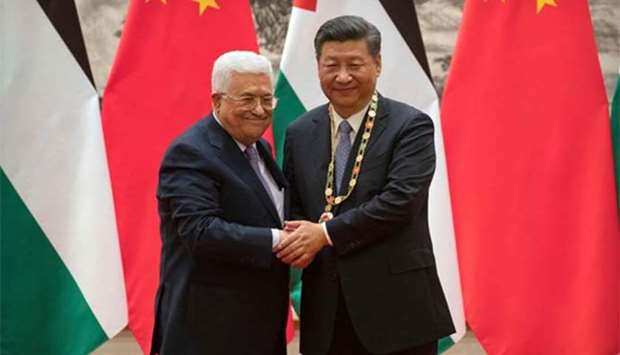 Palestinian President Mahmoud Abbas shakes hands after presenting a medallion to Chinese President Xi Jinping during a signing ceremony at the Great Hall of the People in Beijing on Tuesday.