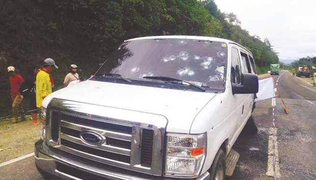 People stand next to the bullet-riddled vehicle in which some members of the Presidential Security Group (PSG) were on board, after they were ambushed by gunmen in Aracan town, north Cotabato province, in the southern island of Mindanao, yesterday.