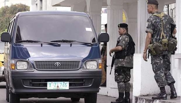 Members of the elite Presidential Security Group in full combat gear inspect a vehicle passing through a gate of the Malacanang palace in Manila. July 8, 2015, file photo.