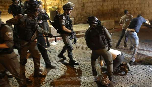 Israeli security forces (L) clash with Palestinian demonstrators (R) in Jerusalem's Old City yesterday