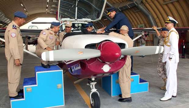 Qatar and Pakistani air forces personnel examining the Super Mushak trainer aircraft.