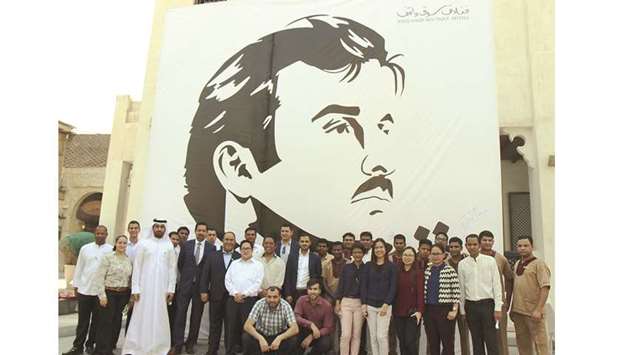 Souq Waqif Boutique Hotels officials and staff in front of the mural.