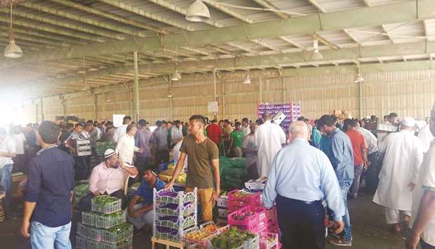 Buyers throng the central fruit and vegetable market in Abu Hamour.
