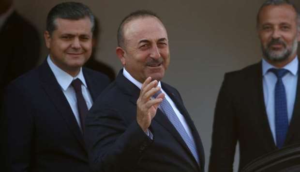 Turkey's Foreign Minister Mevlut Cavusoglu greets journalists during a visit in the Turkish Cypriot northern part of the divided city of Nicosia, Cyprus