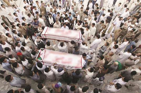Men from the ethnic Hazara community carry the coffins of their relatives who were killed after gunmen opened fire on a car, during a funeral ceremony in Quetta, yesterday.