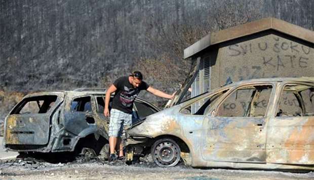 A car owner looking at his burnt out vehicle in Kucine, near the Adriatic town of Split.