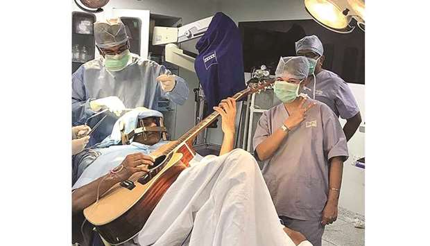 This handout photograph released on July 20, 2017 by Mahveer Jain Hospitals shows 37-year-old patient Abhishek Prasad playing the guitar during a brain surgery, in Bangalore.