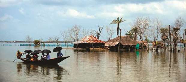 Flooded homes and a broken coastline in Bangladesh.