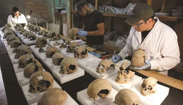Abel Guzman, Rodrigo Bolanos and Miriam Castaneda from INAH examine skulls at a site near Templo Mayor, one of the main temples in the Aztec capital Tenochtitlan, which later became Mexico City.