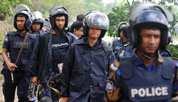 Bangladesh policemen walk during an operation to storm an extremist hideout