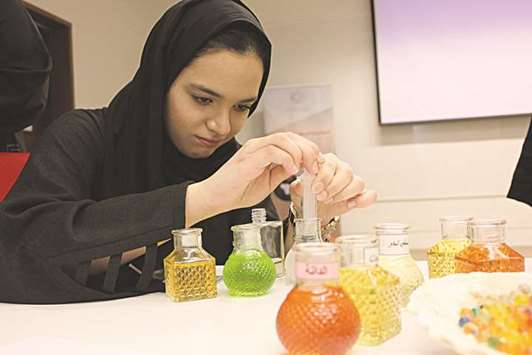 A participant at Qatar Career Development Centeru2019s Summer Career Camp 2017 creates her own perfume.