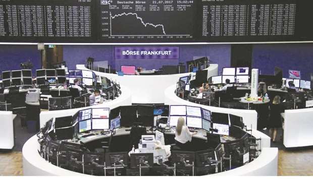 Traders work in front of the DAX board at the Frankfurt Stock Exchange. The DAX 30 slid 1.66% at 12,240.06 points yesterday.