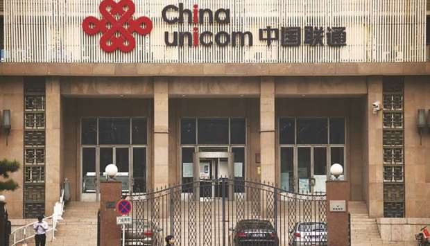 People walk past the China Unicom office building in Beijing. The company is one of the worldu2019s largest mobile carriers by user numbers, but its recent earnings have struggled in a fiercely competitive market.