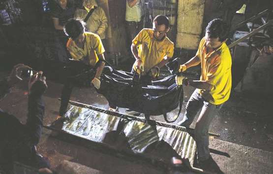 A recent photo shows funeral workers carrying the dead body of an alleged drug dealer killed after a police drug operation in Manila.