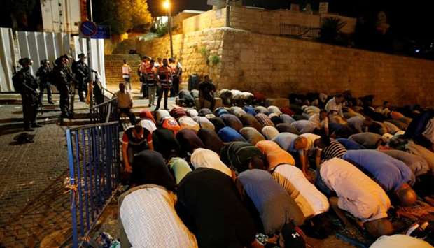 Israeli border police stand guard as Palestinians take part in evening prayers outside the Lion's Gate of Jerusalem's Old City July 20. Reuters