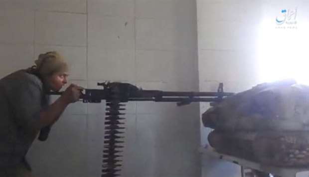 A still image taken from a video posted to a social media website by the Islamic State-affiliated Amaq News Agency, on July 15, 2017, shows a man appearing to be an Islamic State militant firing a weapon, said to be in Raqqa
