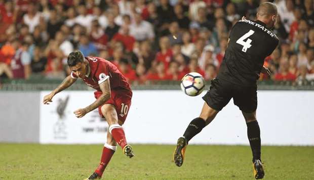 Liverpoolu2019s Philippe Coutinho (L) shoots at goal as Leicester Cityu2019s Danny Drinkwater attempts to block it during their match yesterday.